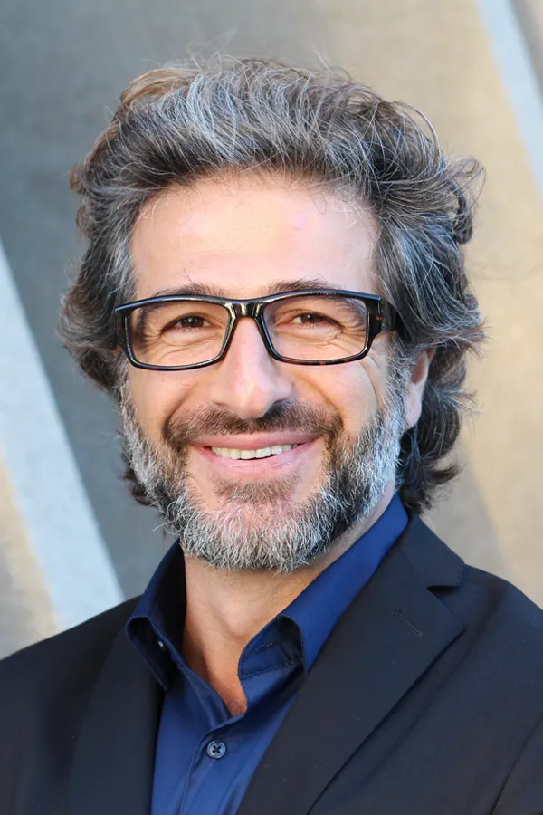 Andropause-and-Low-Testosterone-Treatment A man with glasses, salt and pepper hair and a beard smiling because he received treatment for andropause and low testosterone from Vitality Medical in Seattle.