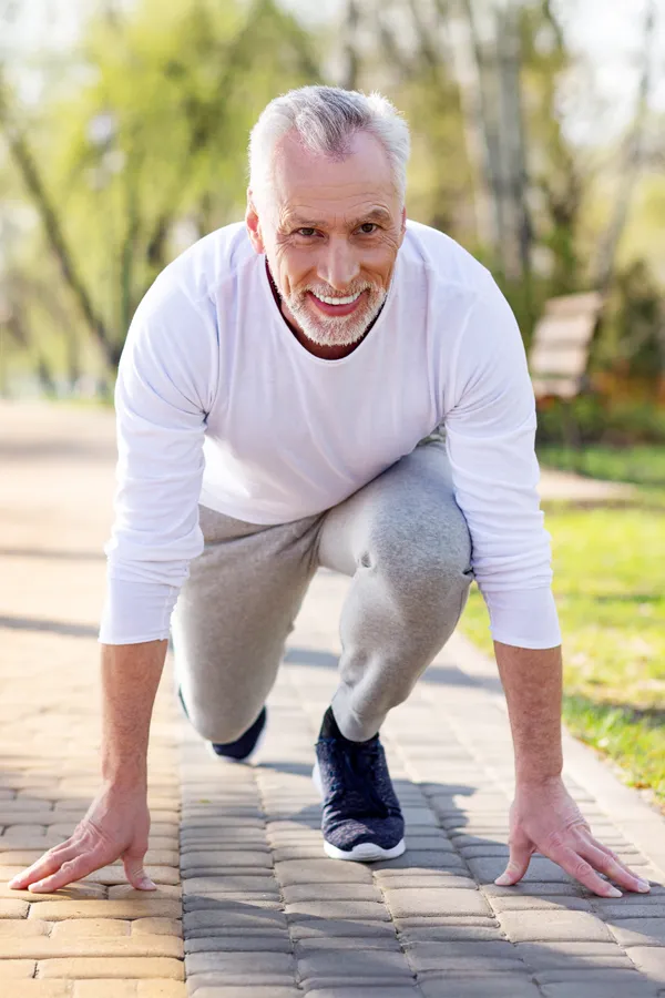 Degenerative-Disc-Disease-Treatment An older man sets in starting position for a run. Get treatment for degenerative disc disease from Vitality Medical in Seattle.