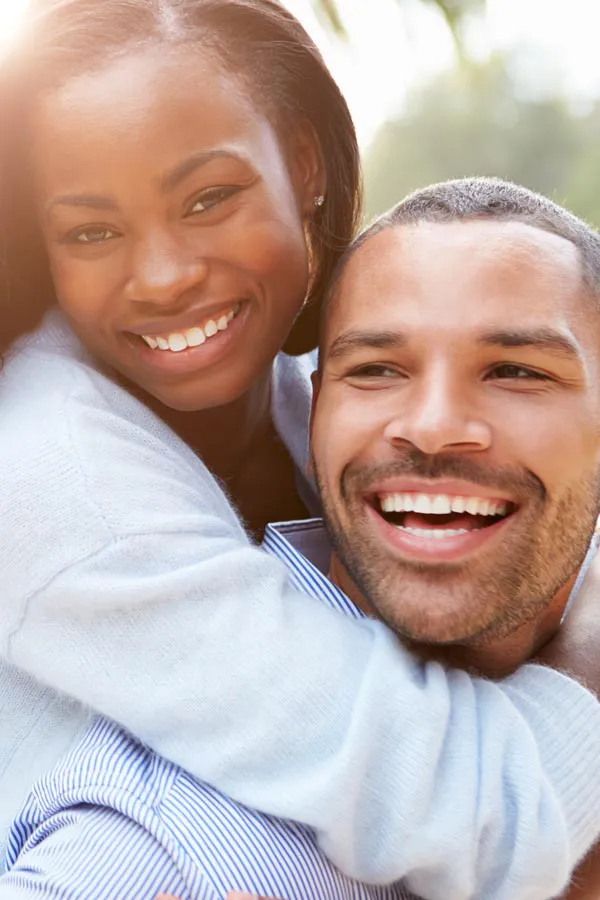 Erectile-Dysfunction-Treatment A woman riding on a man's back, both smiling due to help with erectile dysfunction from Vitality Medical in Seattle.