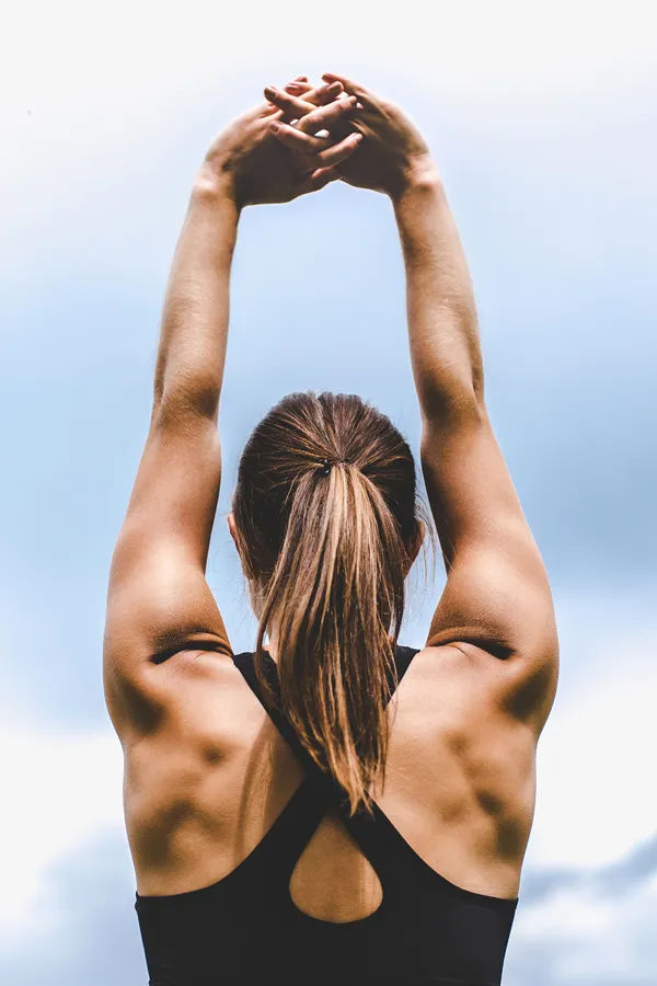 GLP-1-Weight-Loss-Injections-Treatment A toned woman seen from behind stretching her arms into the air. Get GLP-1 Weight Loss Injections from Vitality Medical in Seattle.
