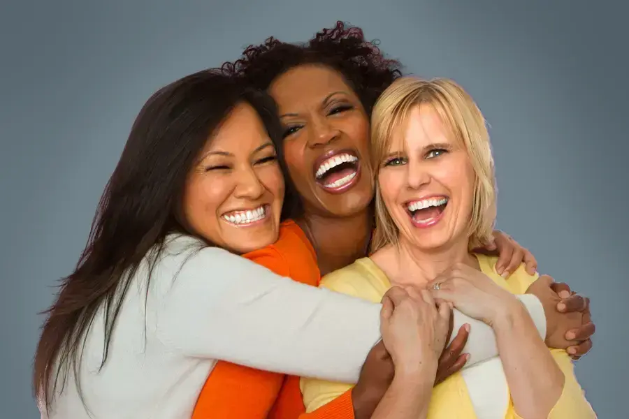 Insulin-Resistance-Clinic An asian, black, and white woman of middle age hug and laugh. Get insulin resistance treatment from Vitality Medical in Seattle.