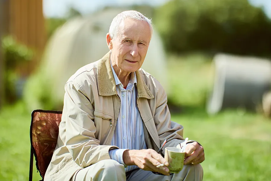 A very thin older man sits outside. Get treatment for muscle atrophy from Vitality Medical in Seattle.