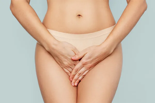 An image focusing on the midsection of a woman, holding her hands protectively over her lower abdomen representing PRP Vaginal Rejuvenation treatment offered by Vitality Medical in Seattle.