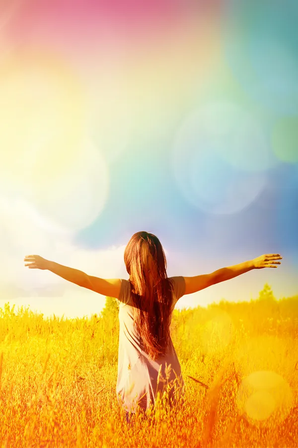 PRP-for-Elbow-Injuries-Treatment A woman stands in a field on a sparkling bright morning with outstretched arms due to successful PRP treatments for elbow pain from Vitality Medical in Seattle.