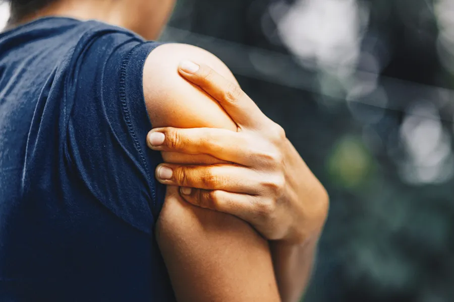 PRP-for-Shoulder-Injury-Doctor Close up of a woman in a tank top holding her shoulder in pain, which can be relieved by PRP treatment for shoulder pain from Vitality Medical in Seattle.