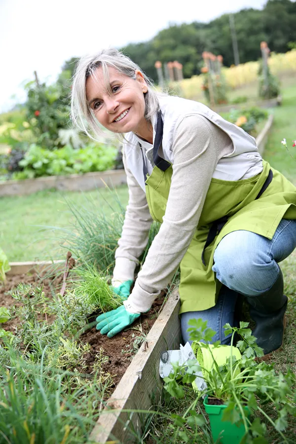 Rheumatoid-Arthritis-Treatment A mature woman bending down working on her garden happily after successful rheumatoid arthritis treatment from Vitality Medical in Seattle.
