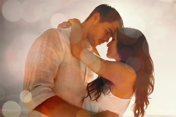 Sexual-Wellness-for-Women-and-Men-Doctor A couple in linen shirts standing in a sparkling light embraces each other with their foreheads touching and eyes closed, happy with their sexual wellness treatments from Vitality Medical in Seattle.