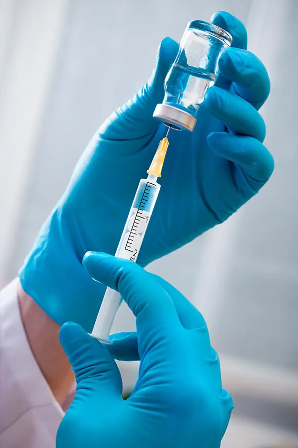 A clinician draws fluid from a vial. Get quercetin Anti-Inflammatory Peptide Treatment from Vitality Medical in Seattle.